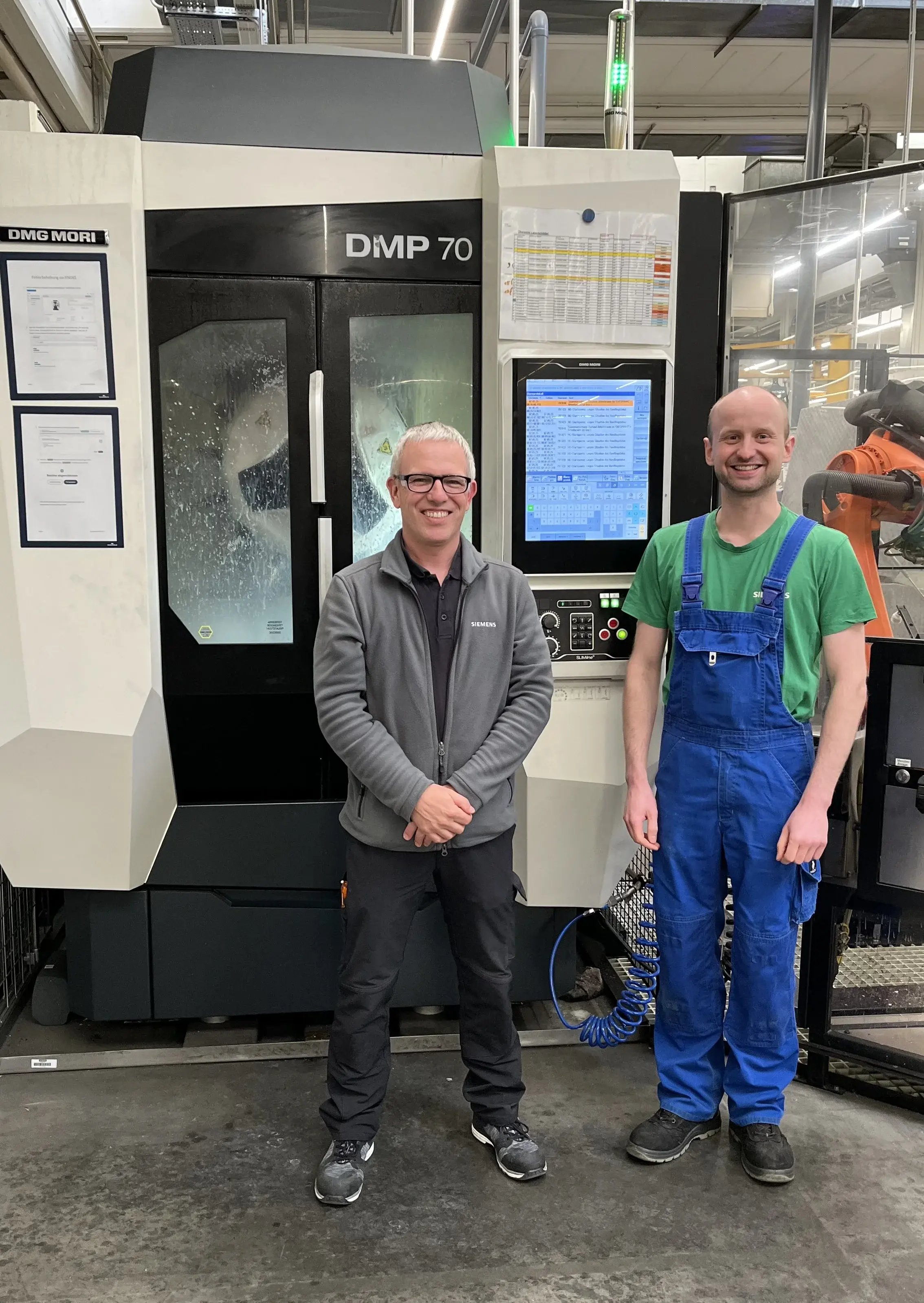 Two Siemens employees in front of a machine